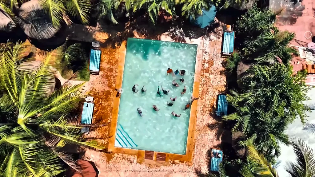 Alberca de Cancún Jungle Camp vista desde el aire, con un grupo jugando adentro, en Puerto Morelos