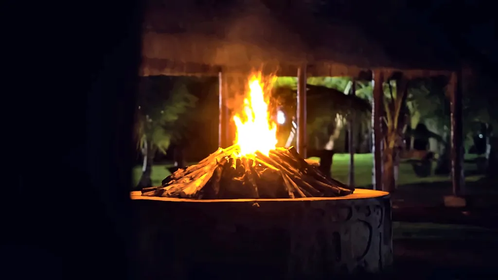 Fogata encendida de noche en el fogón de piedra de Cancún Jungle Camp