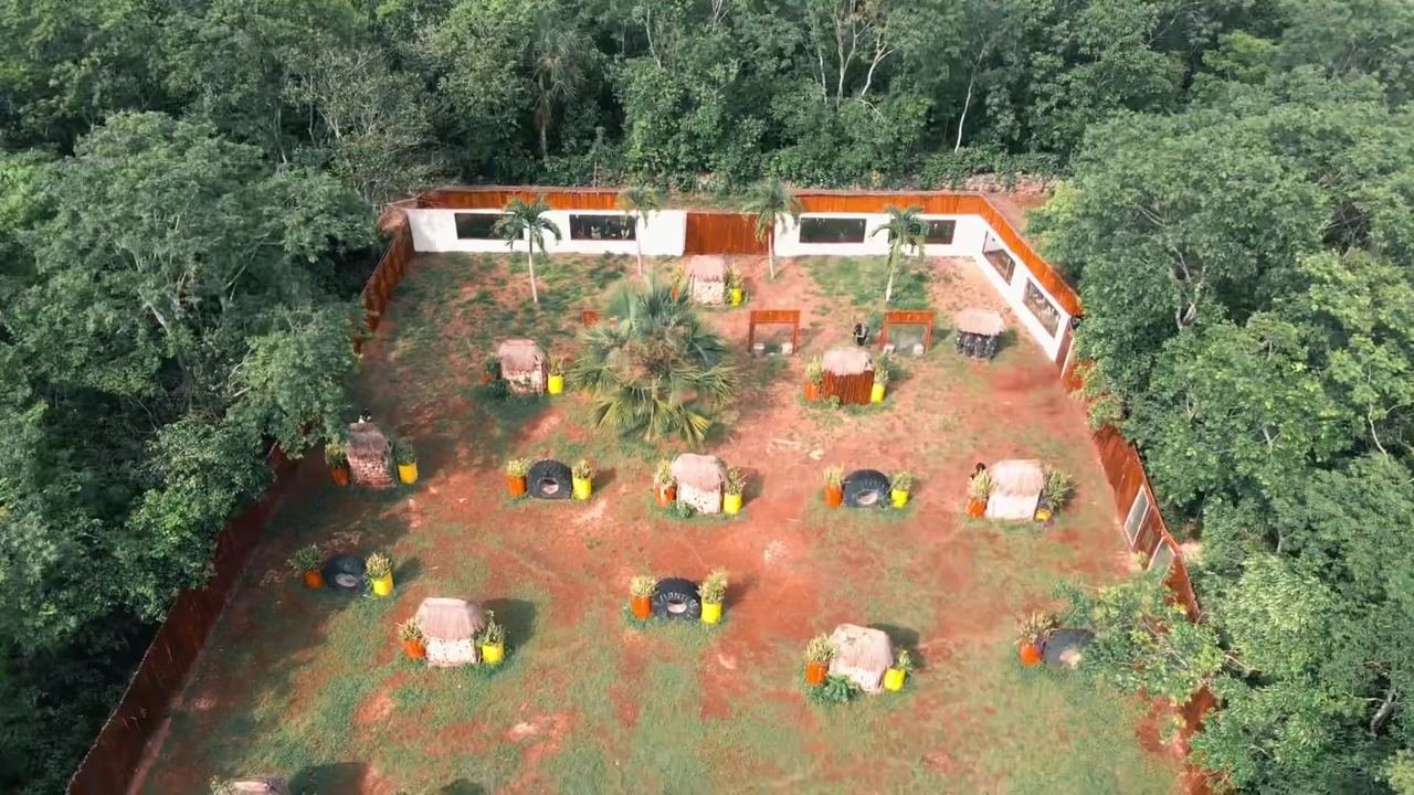 Zona de camping iluminada de noche vista desde un dron, con casas de campaña